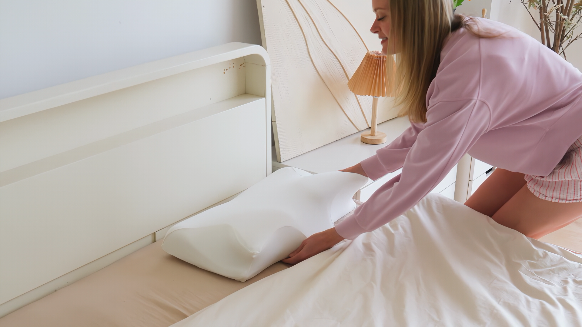 Woman preparing bed with pillow